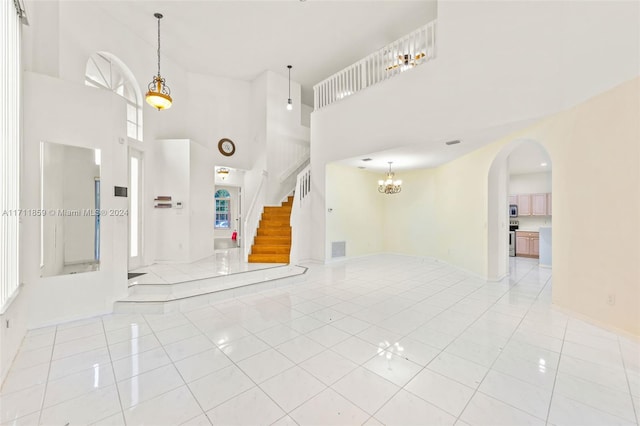 entryway featuring elevator, light tile patterned floors, and a high ceiling