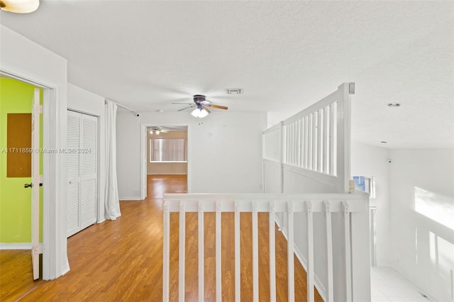 hall featuring a textured ceiling and light wood-type flooring