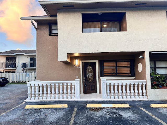 exterior entry at dusk featuring covered porch