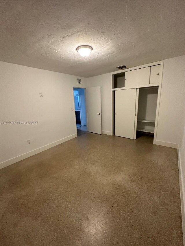 unfurnished bedroom with a textured ceiling and a closet