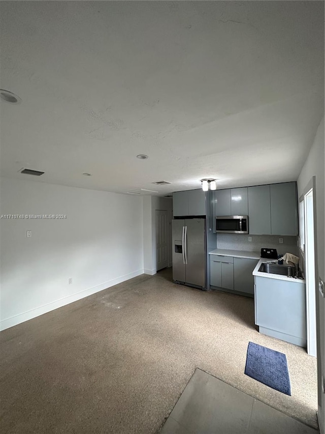 kitchen featuring stainless steel appliances, gray cabinetry, and sink