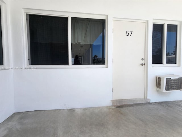 1504 S Surf Rd Unit 57, Hollywood, FL 33019 - doorway to property featuring a wall mounted air conditioner and stucco siding