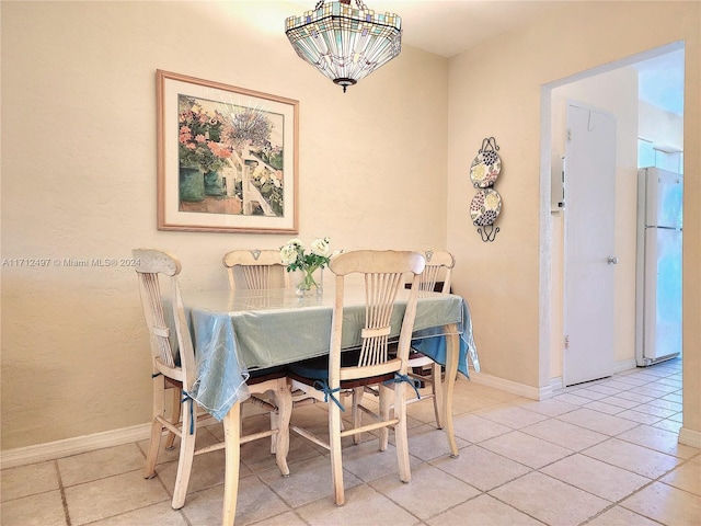 tiled dining space featuring an inviting chandelier