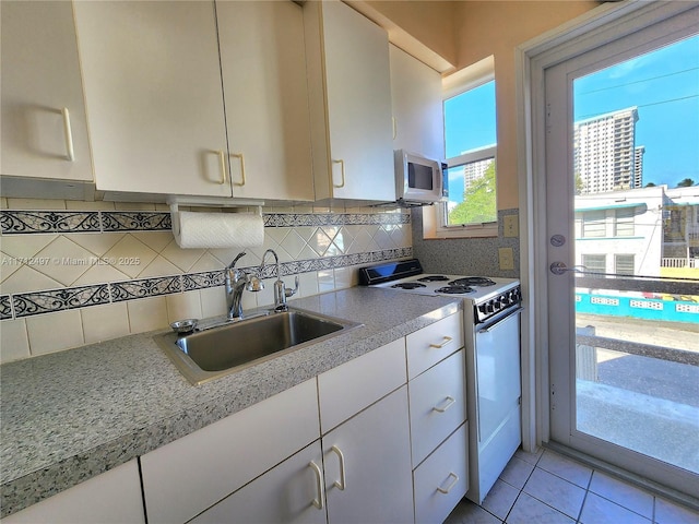 1504 S Surf Rd Unit 57, Hollywood, FL 33019 - kitchen with a sink, white microwave, light countertops, white cabinets, and range with electric cooktop