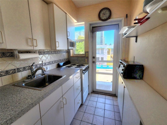 1504 S Surf Rd Unit 57, Hollywood, FL 33019 - kitchen with white appliances, a sink, white cabinets, tasteful backsplash, and light countertops