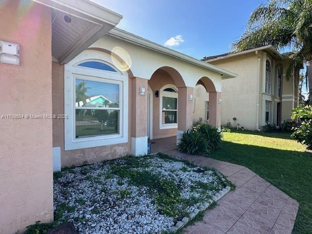 doorway to property featuring a yard