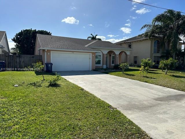 view of front of property featuring a front yard and a garage