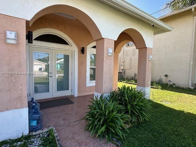 doorway to property featuring a lawn and french doors