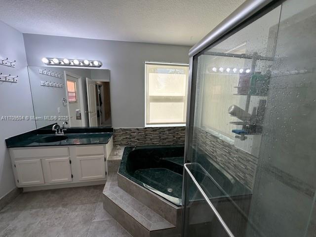 bathroom featuring a textured ceiling, tile patterned floors, vanity, and independent shower and bath