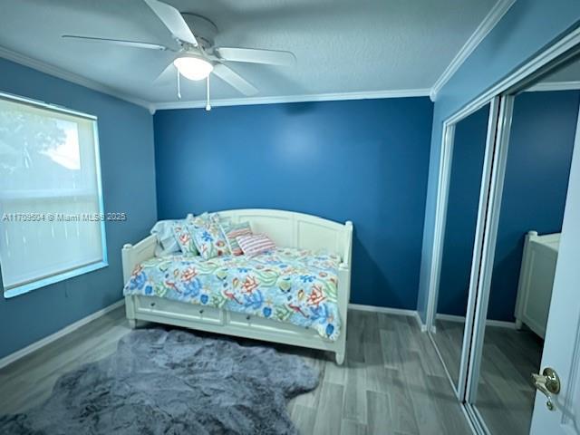 bedroom featuring ceiling fan, wood-type flooring, and ornamental molding