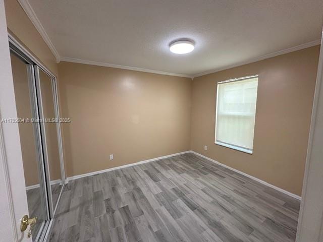 empty room featuring crown molding and light hardwood / wood-style flooring