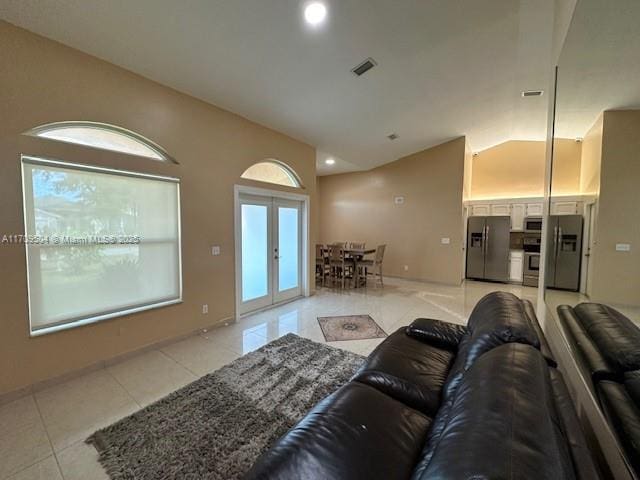 living room with lofted ceiling, light tile patterned floors, french doors, and plenty of natural light