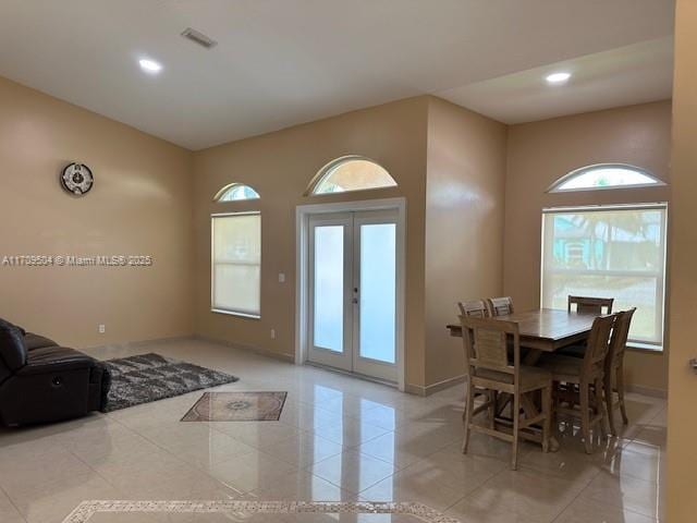 interior space with light tile patterned floors, french doors, and a healthy amount of sunlight