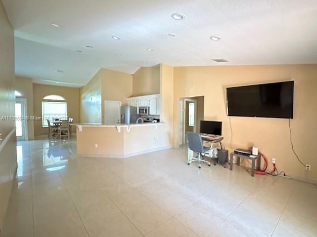 living room featuring vaulted ceiling and light tile patterned floors