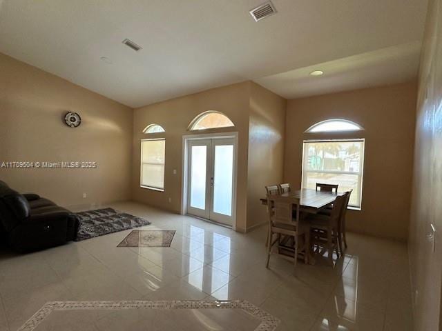 entryway featuring light tile patterned floors, a healthy amount of sunlight, and french doors