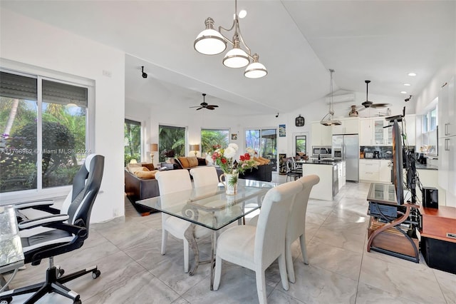 dining room featuring ceiling fan, a healthy amount of sunlight, and vaulted ceiling