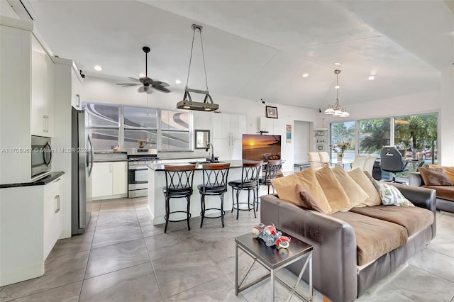 living room featuring ceiling fan, sink, and vaulted ceiling