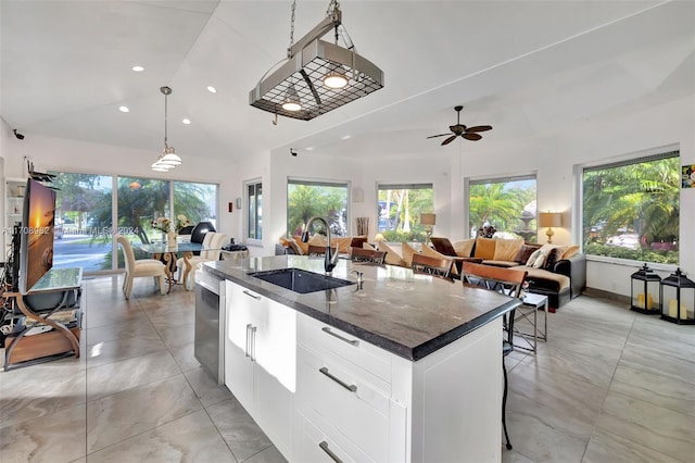 kitchen with pendant lighting, sink, ceiling fan, an island with sink, and white cabinetry