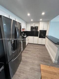 kitchen featuring light wood-type flooring, stainless steel appliances, and white cabinetry