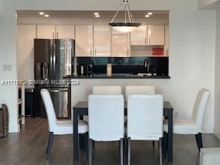 kitchen with white cabinets, stainless steel fridge with ice dispenser, dark hardwood / wood-style floors, and hanging light fixtures