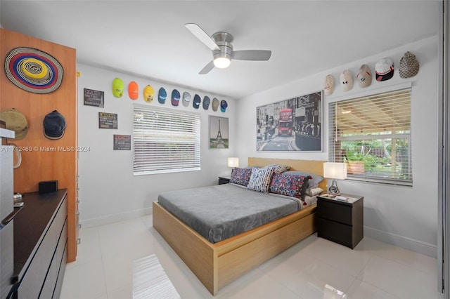 tiled bedroom featuring multiple windows and ceiling fan