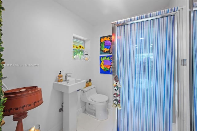 bathroom with tile patterned floors, toilet, and walk in shower