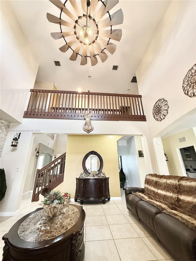 living room with light tile patterned floors, a high ceiling, and an inviting chandelier