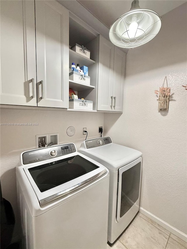 clothes washing area with light tile patterned floors, cabinets, and independent washer and dryer