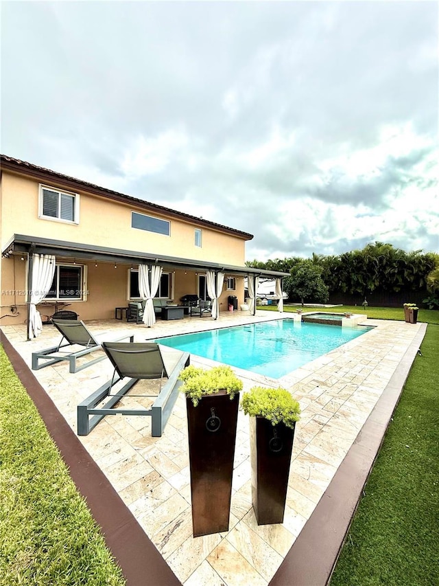 view of swimming pool featuring an in ground hot tub and a patio