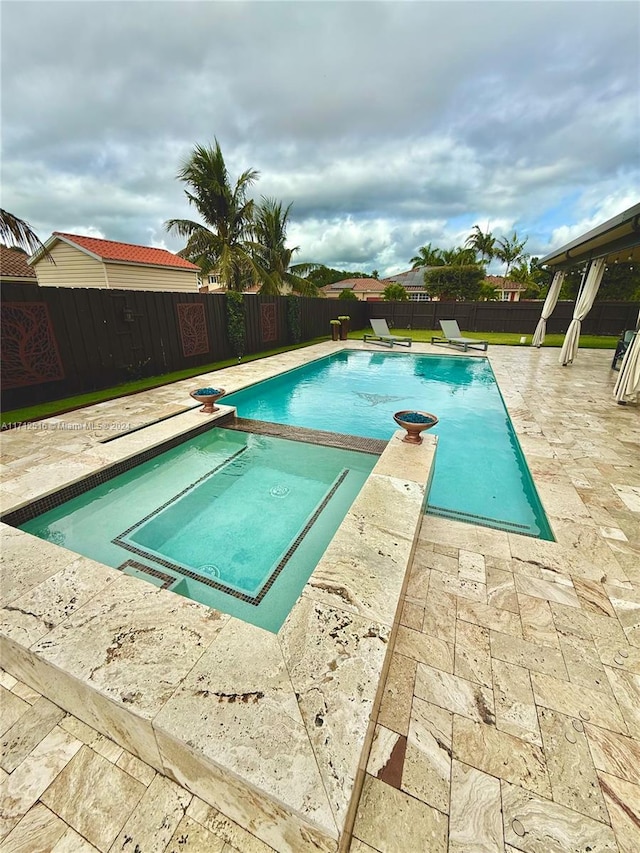 view of swimming pool featuring a diving board, an in ground hot tub, and a patio