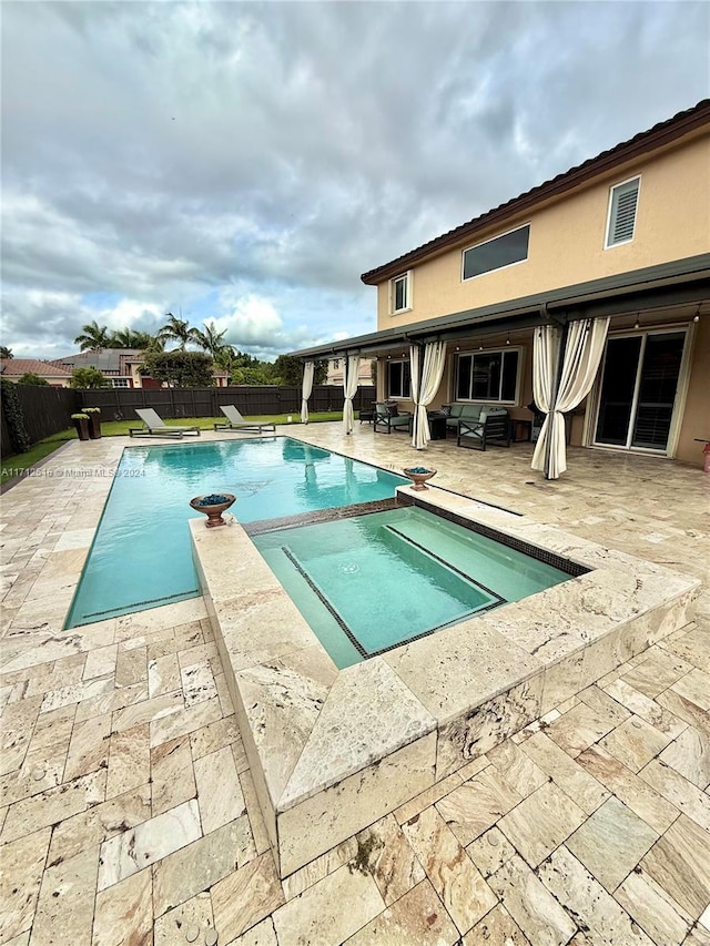 view of pool with an in ground hot tub and a patio