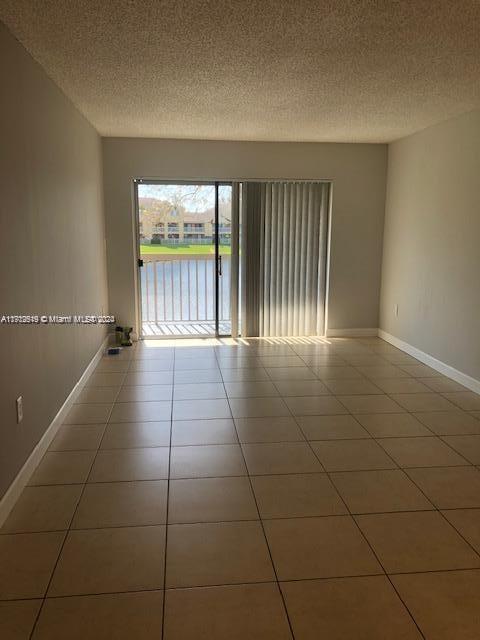 5200 NW 31st Ave Unit 155, Fort Lauderdale, FL 33309 - empty room featuring a textured ceiling and tile patterned flooring