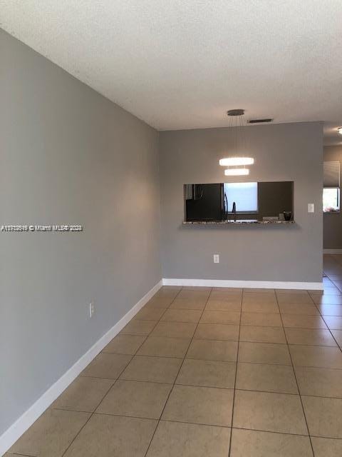 5200 NW 31st Ave Unit 155, Fort Lauderdale, FL 33309 - empty room featuring tile patterned floors, healthy amount of natural light, and a textured ceiling