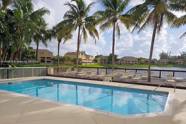 view of swimming pool with a water view and a patio area