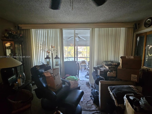 carpeted living room featuring ceiling fan and a textured ceiling