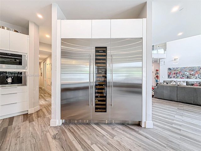 kitchen featuring white cabinets, appliances with stainless steel finishes, and light wood-type flooring