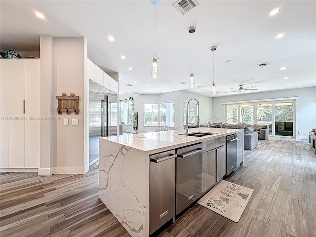 kitchen with decorative light fixtures, light hardwood / wood-style flooring, plenty of natural light, and a large island