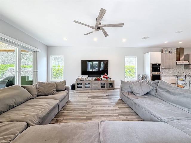 living room with ceiling fan and light hardwood / wood-style flooring