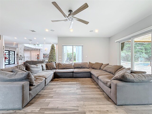 living room with ceiling fan, a healthy amount of sunlight, and light hardwood / wood-style floors