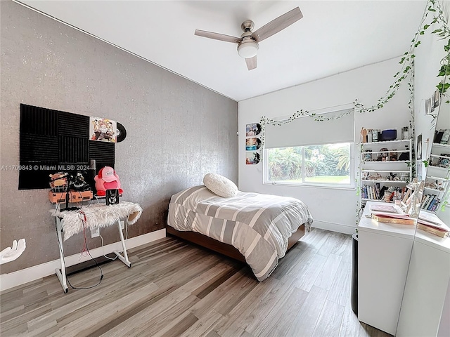 bedroom featuring hardwood / wood-style floors, ceiling fan, and washer and dryer