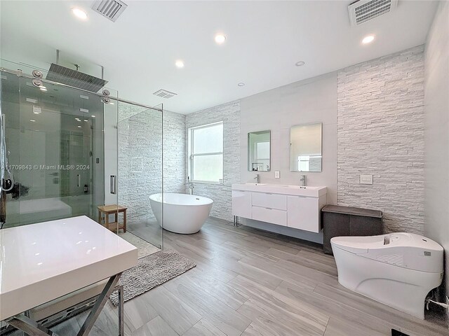 bathroom featuring hardwood / wood-style floors, vanity, and shower with separate bathtub