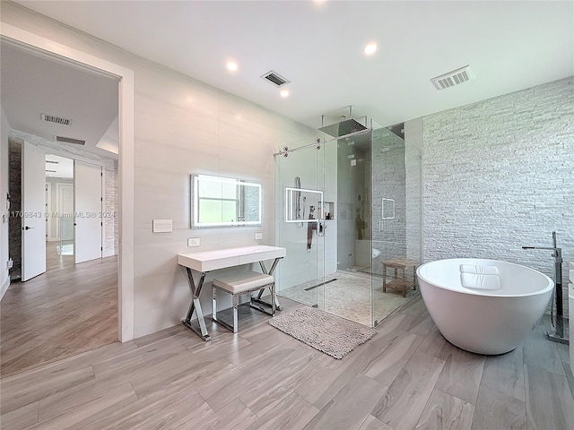 bathroom with hardwood / wood-style floors and separate shower and tub