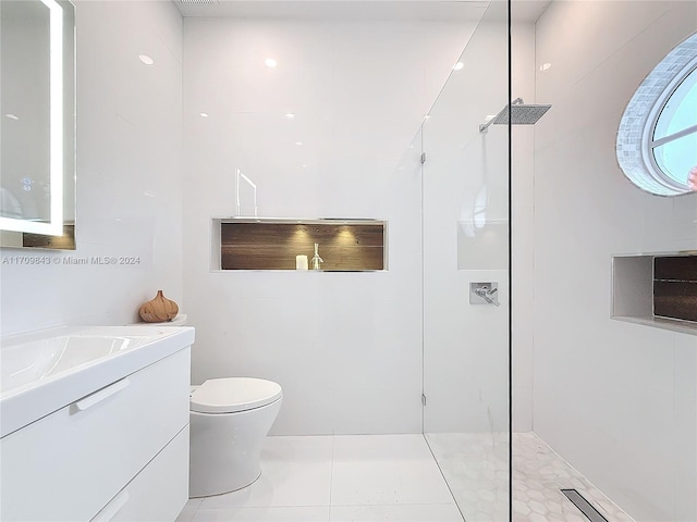 bathroom with tile patterned floors, vanity, toilet, and walk in shower