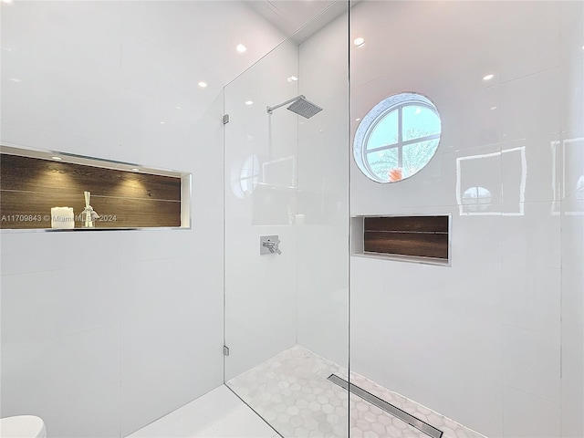 bathroom with tiled shower and tile patterned flooring