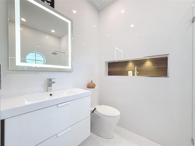 bathroom featuring tile patterned flooring, vanity, toilet, and a shower