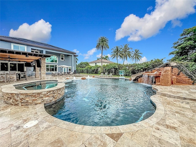 view of pool with an in ground hot tub, pool water feature, and a patio