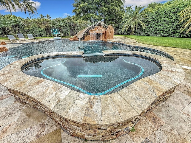 view of pool featuring an in ground hot tub and a water slide