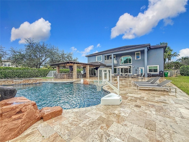 view of swimming pool featuring pool water feature and a patio