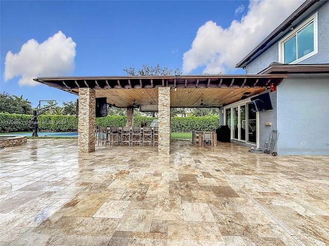 view of patio / terrace with ceiling fan and an outdoor bar