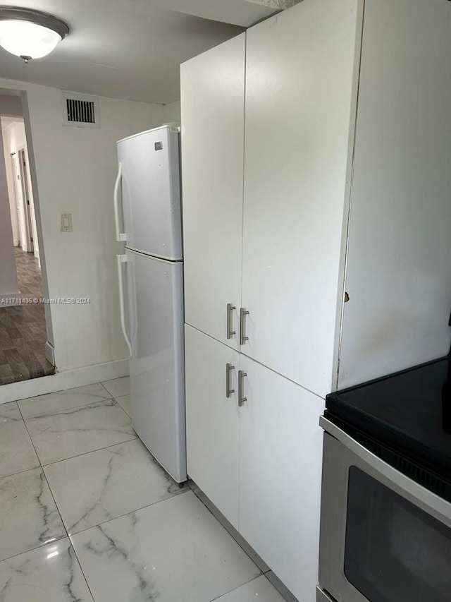 kitchen featuring white cabinets and white appliances